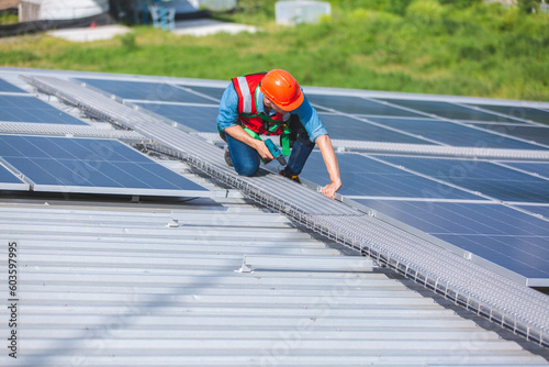 Wallpaper Mural Male professional engineer installing solar photovoltaic panel system, Electrician mounting blue solar module technology on power industrial factory roof, Alternative energy ecological technician job Torontodigital.ca