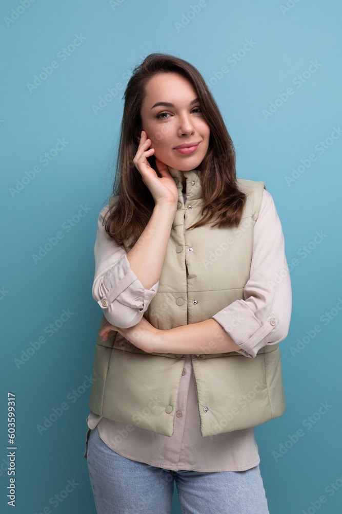 charming positive brunette young lady in casual style on studio background charming positive brunette young lady in casual style on studio background