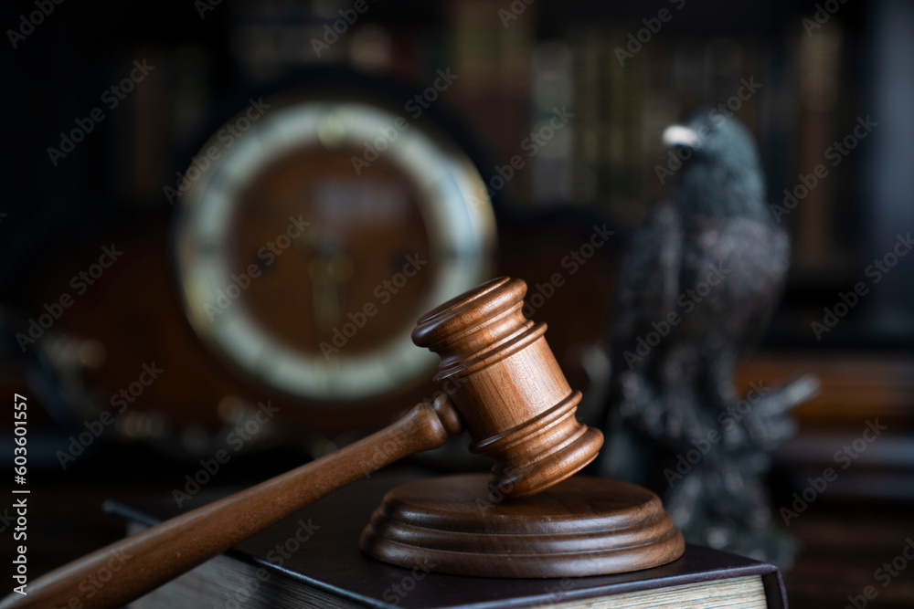 Lawyer office. Judge’s gavel, Themis sculpture and legal books in the bookshelf. Lawyer office. Judge’s gavel, Themis sculpture and legal books in the bookshelf.