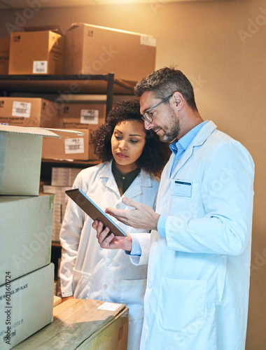 Tablet, box and pharmacy with people and checklist for shipping, cargo or medical supplies. Digital, inventory and delivery with man and woman in storage room for medicine, healthcare and drugs store photo