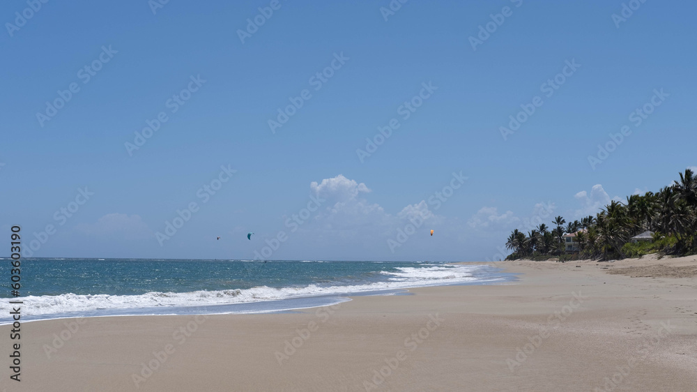 Tropical beach, turquoise sea water, ocean wave, yellow sand, green palm trees, sunny blue sky, white clouds, beautiful seascape, summer holidays, holidays on exotic islands, travel