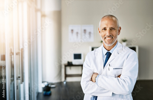Mature doctor  smile and portrait with arms crossed in hospital feeling proud from medical work. Healthcare  wellness and professional employee with happiness from health support and physician job