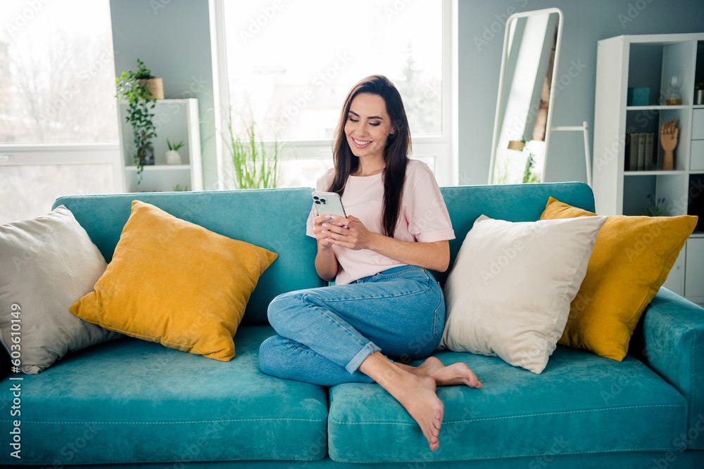 Full body portrait of pretty cheerful lady sitting comfort sofa use smart phone enjoy peaceful day apartment inside Full body portrait of pretty cheerful lady sitting comfort sofa use smart phone enjoy peaceful day apartment inside