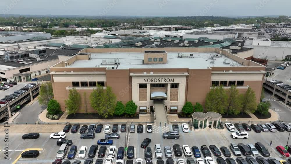Aerial truck shot of large Nordstrom outlet attached to major shopping center. Cars navigate traffic in busy parking lot outside of trendy retail store for teens and young adults. Mall, shopping theme