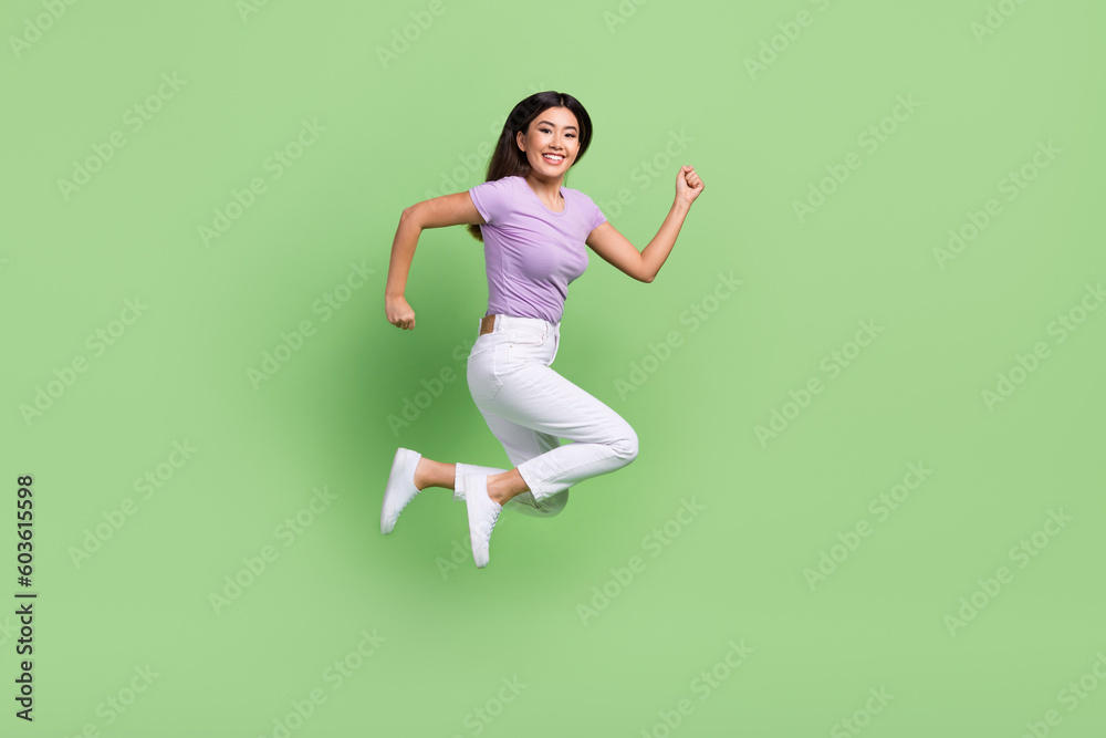 Full length body cadre of running vietnamese attractive funny lady hurry jumping deadline motivation isolated on green color background Full length body cadre of running vietnamese attractive funny lady hurry jumping deadline motivation isolated on green color background