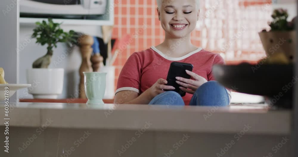 Happy biracial woman using smartphone at home in slow motion Happy biracial woman using smartphone at home in slow motion