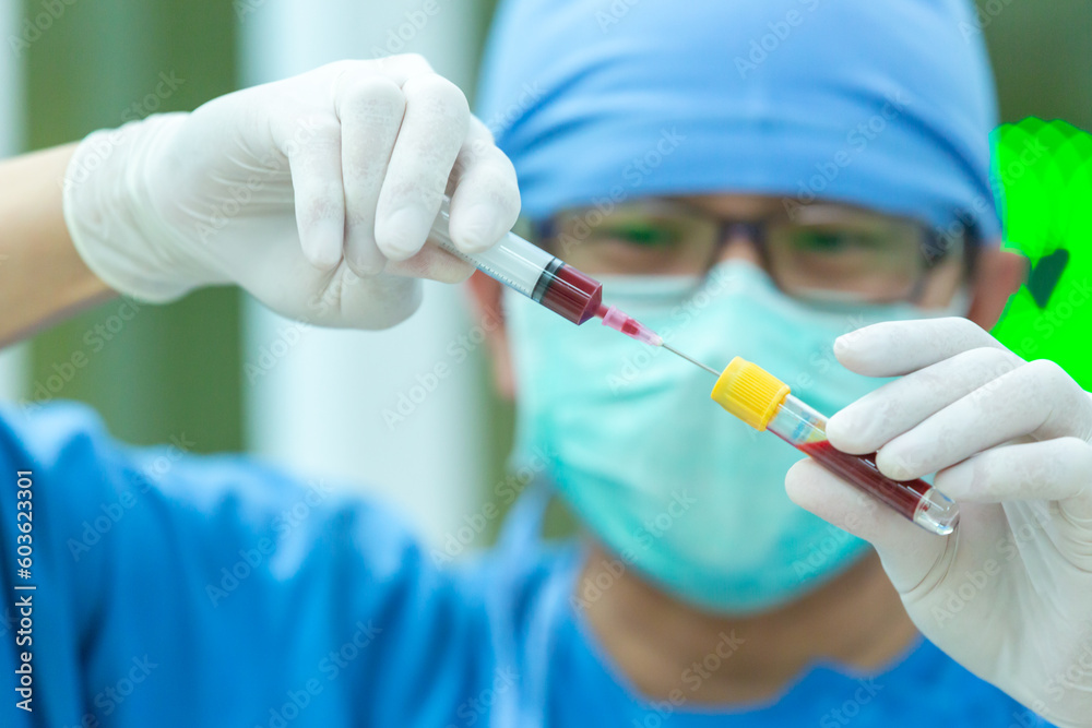 The doctor with a syringe of blood sample and a rack with other samples. Technician holding blood syringe sample for study. The doctor with a syringe of blood sample and a rack with other samples. Technician holding blood syringe sample for study.