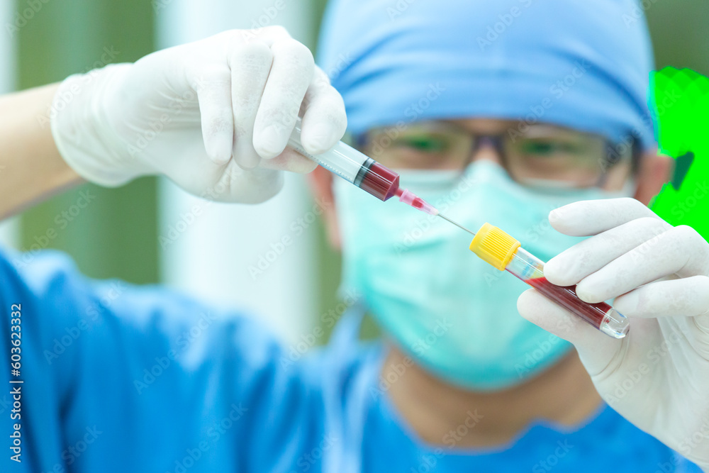 The doctor with a syringe of blood sample and a rack with other samples. Technician holding blood syringe sample for study. The doctor with a syringe of blood sample and a rack with other samples. Technician holding blood syringe sample for study.