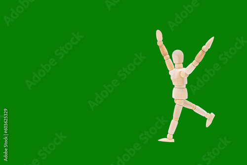 Photograph of a wooden mannequin with green coloured background. Photo to be able to crop. Concepts. Selective focus. Space for copy