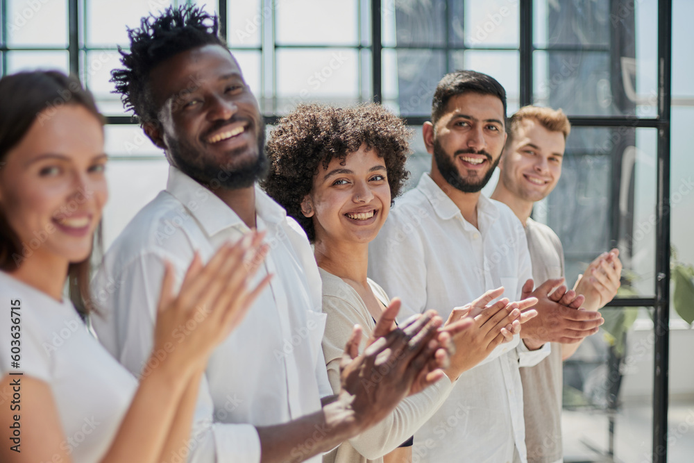 Group of businesspeople sitting in a line and applauding. Group of businesspeople sitting in a line and applauding.