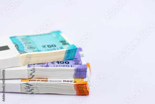 High angle close up shot of new fifty, one and two hundred rupee notes on white background, showing finance concept. photo