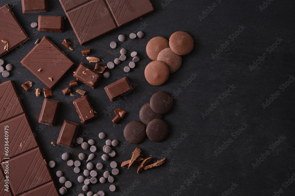 Top view of bars and pieces of different milk and dark chocolate on dark concrete background with copy space. Top view of bars and pieces of different milk and dark chocolate on dark concrete background with copy space.