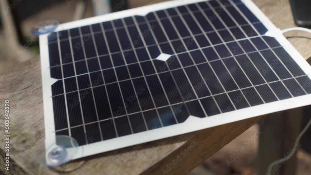 Charging a smartphone with a portable solar panel. camping.