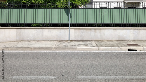 Wallpaper Mural House fence consisting of a low concrete wall with metal railing and a green plastic panel. Cement sidewalk and asphalt street in front. Background for copy space. Torontodigital.ca