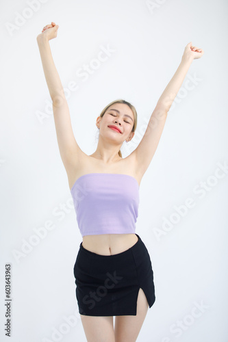 Portrait studio isolated cutout shot of Millennial Asian beautiful pretty cheerful female model in tube cropped top casual shirt holding hands up closed eyes stretching arms on white background © Bangkok Click Studio