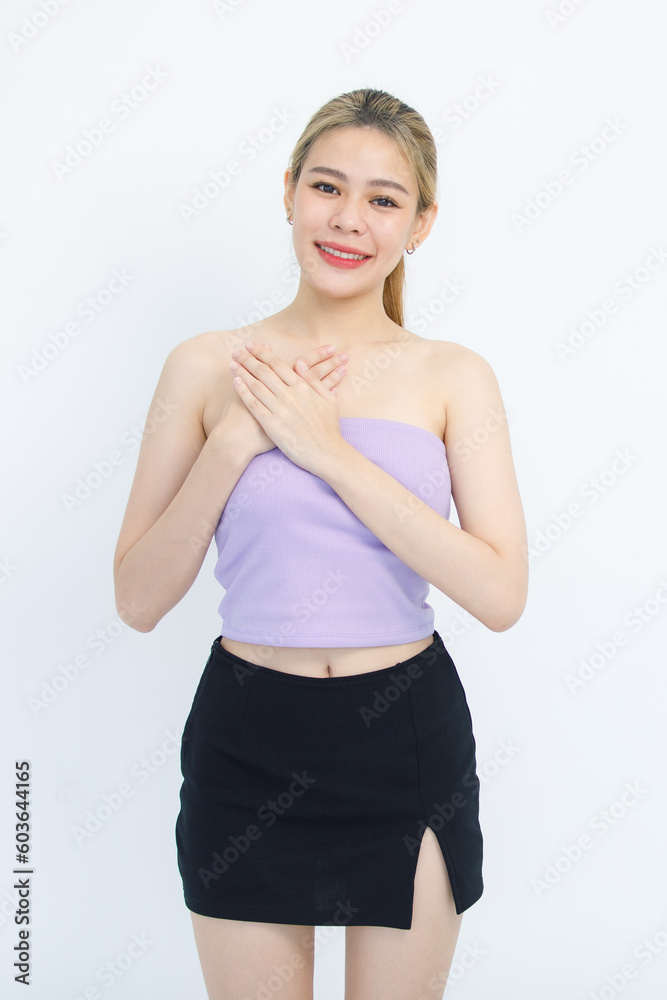 Portrait isolated cutout studio shot of Asian beautiful pretty happy cheerful thankful female model in tube cropped top shirt standing smiling holding hands together on chest on white background Portrait isolated cutout studio shot of Asian beautiful pretty happy cheerful thankful female model in tube cropped top shirt standing smiling holding hands together on chest on white background