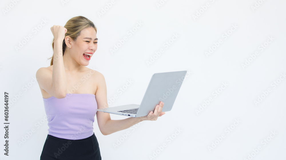 Isolated cutout studio shot of Asian excited surprised happy cheerful female model standing smiling looking at laptop computer winning lottery achievement victory goal deal done on white background Isolated cutout studio shot of Asian excited surprised happy cheerful female model standing smiling looking at laptop computer winning lottery achievement victory goal deal done on white background
