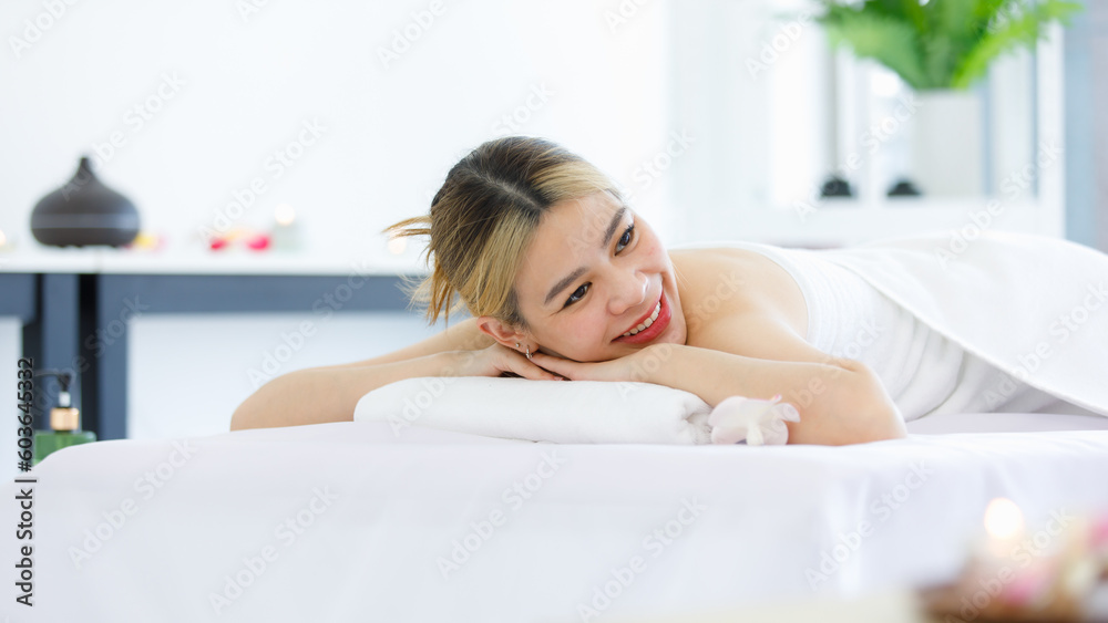 Portrait shot of Millennial Asian young beautiful relaxing resting nude naked woman laying lying down smiling look at camera on comfortable massage bed under clean white towel waiting for masseuse Portrait shot of Millennial Asian young beautiful relaxing resting nude naked woman laying lying down smiling look at camera on comfortable massage bed under clean white towel waiting for masseuse