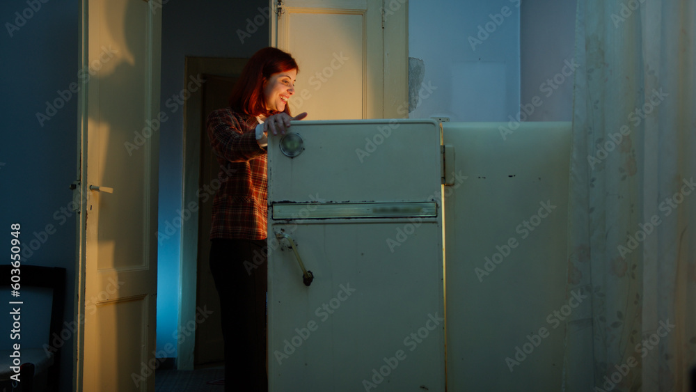 Woman smile and looks into a fridge