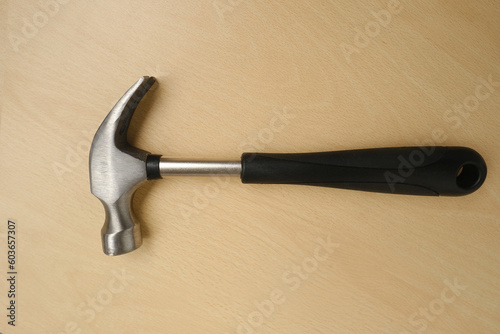 rubber-handled hammer with nail puller, round head for fine work, manual universal percussion tool for driving and extracting nails, geology and construction, breaking, carpentry, locksmith work photo