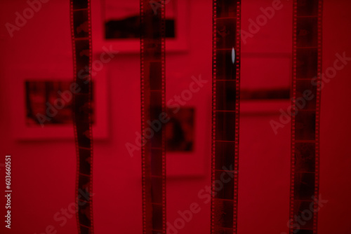 Close-up of photo film hanging in darkroom with red lighting