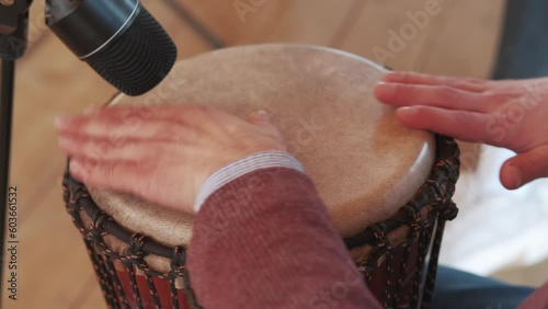 Close up video of man hands playing at traditional djembe drum. photo