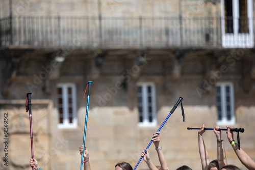 Pilgrims on the Camino de Santiago arrive at the Plaza del Obradoiro because they have finished their pilgrimage. A group of pilgrims raise their walking sticks to celebrate their arrival at the cathe photo