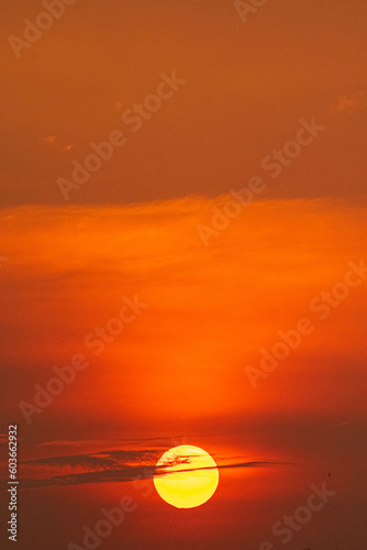 Deep orange sundown in sky at sunset. © Parichart