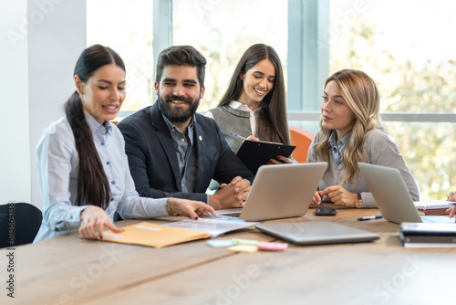Young embarrassed and shy woman, a new employer getting ready to show first project and ideas in front of multi-ethnic and multi-aged colleagues at conference business meeting.