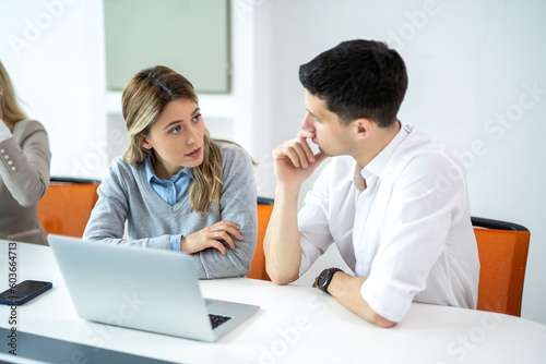 Serious woman and man discussing new online business trends. Business woman explaining start up project to her male colleague who is listening with attention