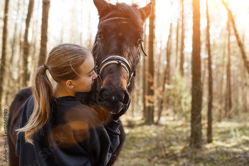 a young girl jockey hugs a horse