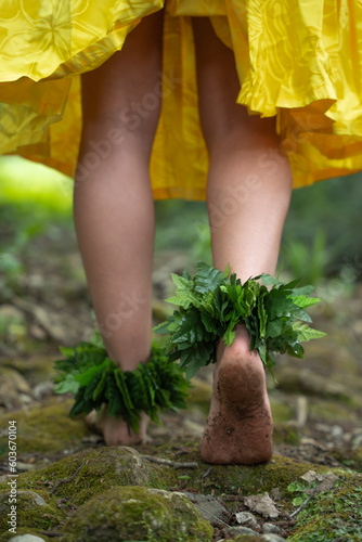 Close up closeup of the dirty feet of a young hula dancer woman wearing anklets made from tropical plant leaves.