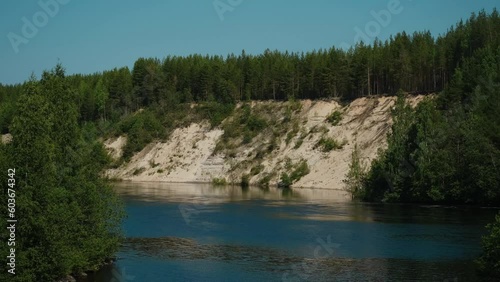 The nature of Russia. The observation deck of Girvas paleovolcano, Karelia. Popular tourist destination. View of green coniferous forest in summer, sandy mountain and wide blue calm river or lake. photo