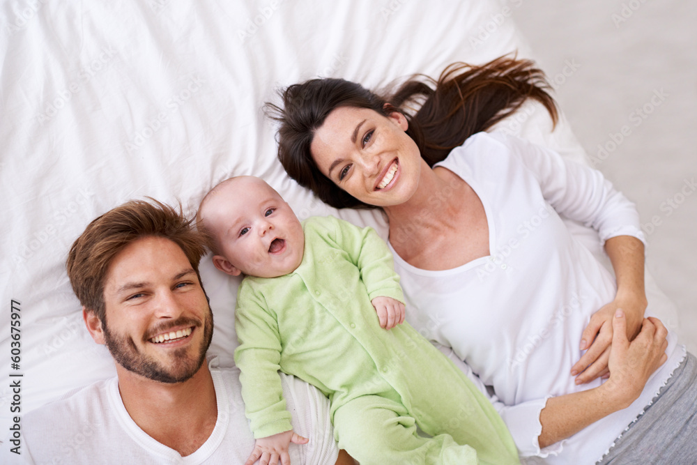 Top view, portrait and happy parents with baby on bed for love, care and quality time together at home. Smile of mother, father and family with cute newborn kid relaxing in bedroom, fun and happiness Top view, portrait and happy parents with baby on bed for love, care and quality time together at home. Smile of mother, father and family with cute newborn kid relaxing in bedroom, fun and happiness