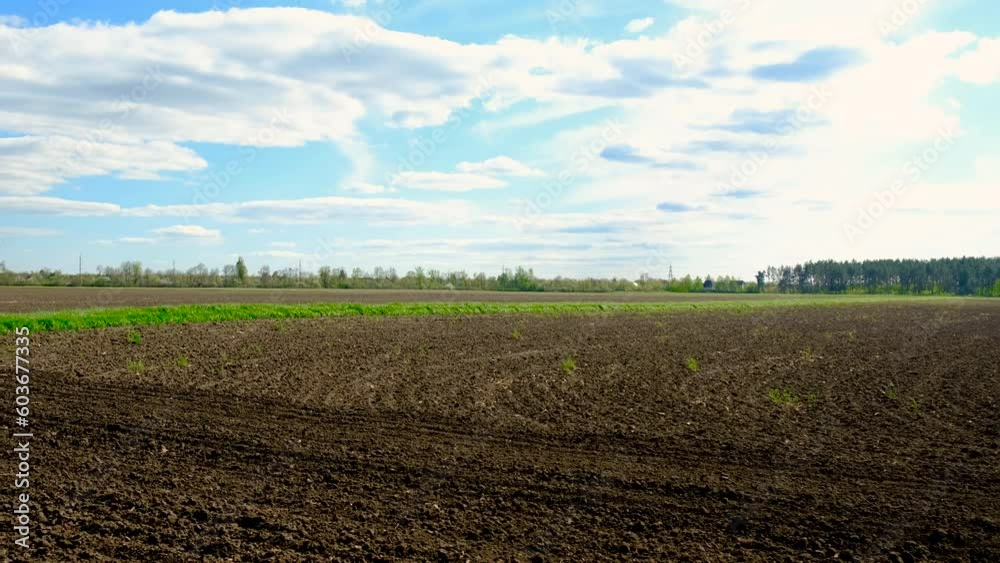 The tractor on the field cultivates the soil. Selective focus. The tractor on the field cultivates the soil. Selective focus.