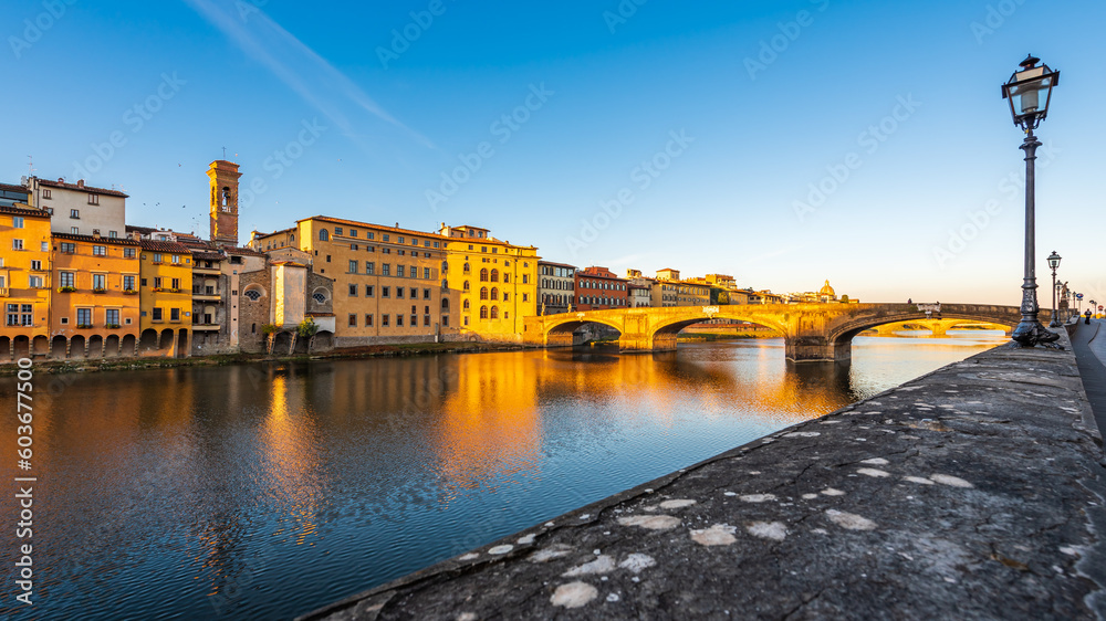 The Ponte Santa Trinita bridge over the Arno river in Florence enlighten by a strong sunlight in the morning.
