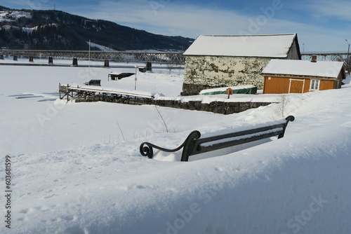 Am Ufer des Mjösa-Sees in Lillehammer steht diese Bank. Sie ist an diesem Wintertag im Februar mit einer dicken Schneeschicht bedeckt. photo