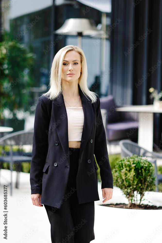 Business women style. Woman going to work walking on the street. Portrait of beautiful smiling female in stylish office clothes going on the street.