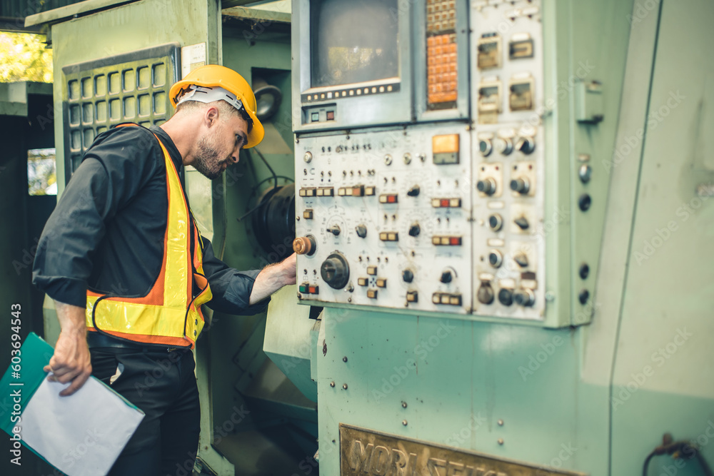 young engineer male worker work check service old CNC lathe machine in heavy metal industry young engineer male worker work check service old CNC lathe machine in heavy metal industry
