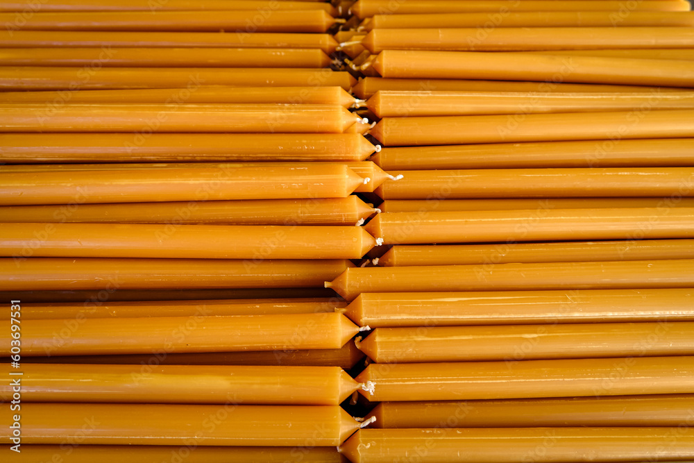Pile of new yellow wax candles used in churches, close-up.