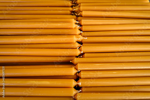 Obraz na płótnie Pile of new yellow wax candles used in churches, close-up. w salonie
