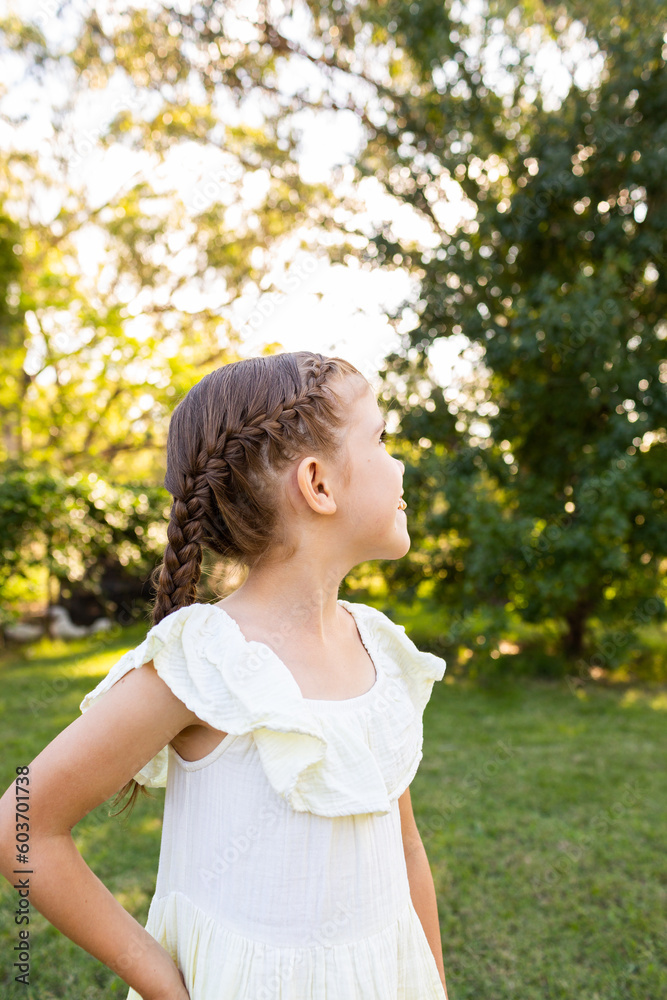Young girl with braided hair looking to side outside Young girl with braided hair looking to side outside