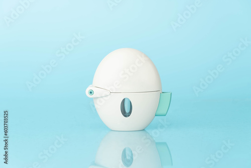 Asthma and COPD concept. Tiotropium bromide inhaler with reflection on light blue background. Pharmaceutical device of bronchodilator for lung inflammation treatment and prevent asthma attack. photo