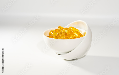 Fish Oil Omega 3 on white background,  vitamin D yellow supplement gel capsules, macro shot 