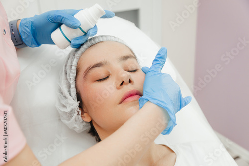Beautician's hands apply cream on woman's forehead. Skin treatment. Spa beauty treatments. cream after botoxre