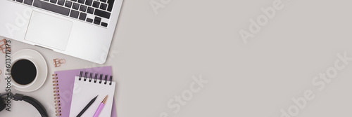 Banner with stationery  laptop  cup of coffee and headphones on a gray background. Workspace with place for text.