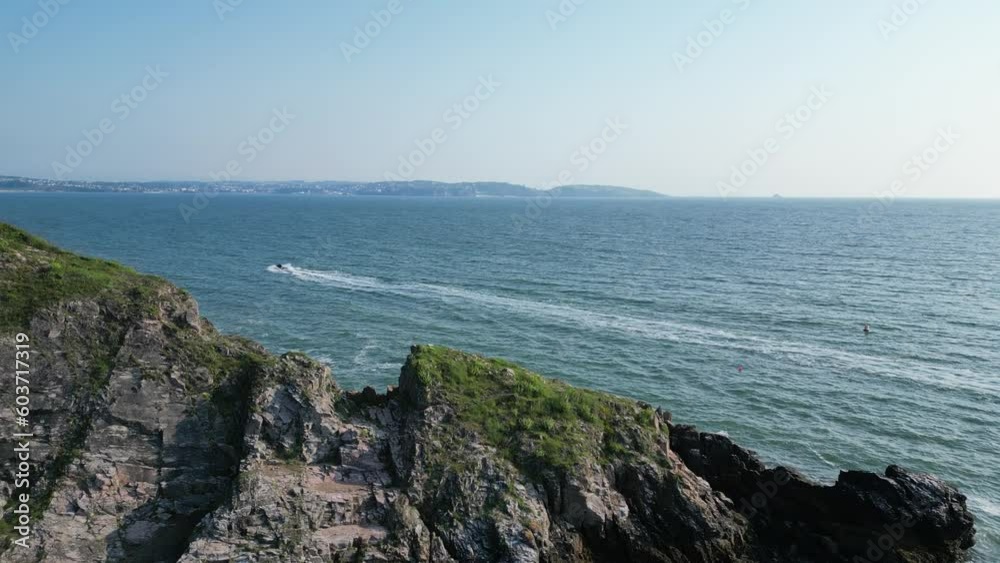 Churston Cove, Torbay, South Devon, England: DRONE AERIAL VIEWS: Drone ascends over cliffs as a speedboat heads across the Torbay sea; Drone traces the speedboat. Churston Cove, Torbay, South Devon, England: DRONE AERIAL VIEWS: Drone ascends over cliffs as a speedboat heads across the Torbay sea; Drone traces the speedboat.