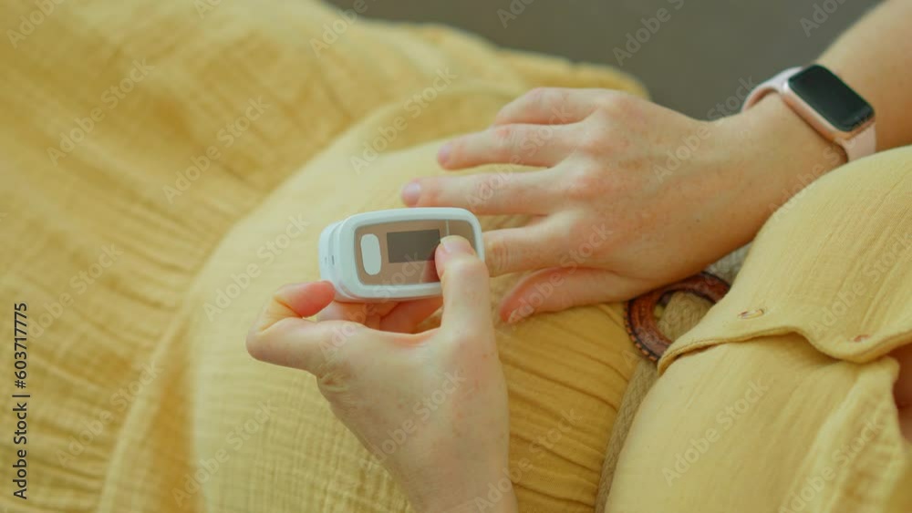 In this video, a pregnant woman is seen measuring her oxygen levels