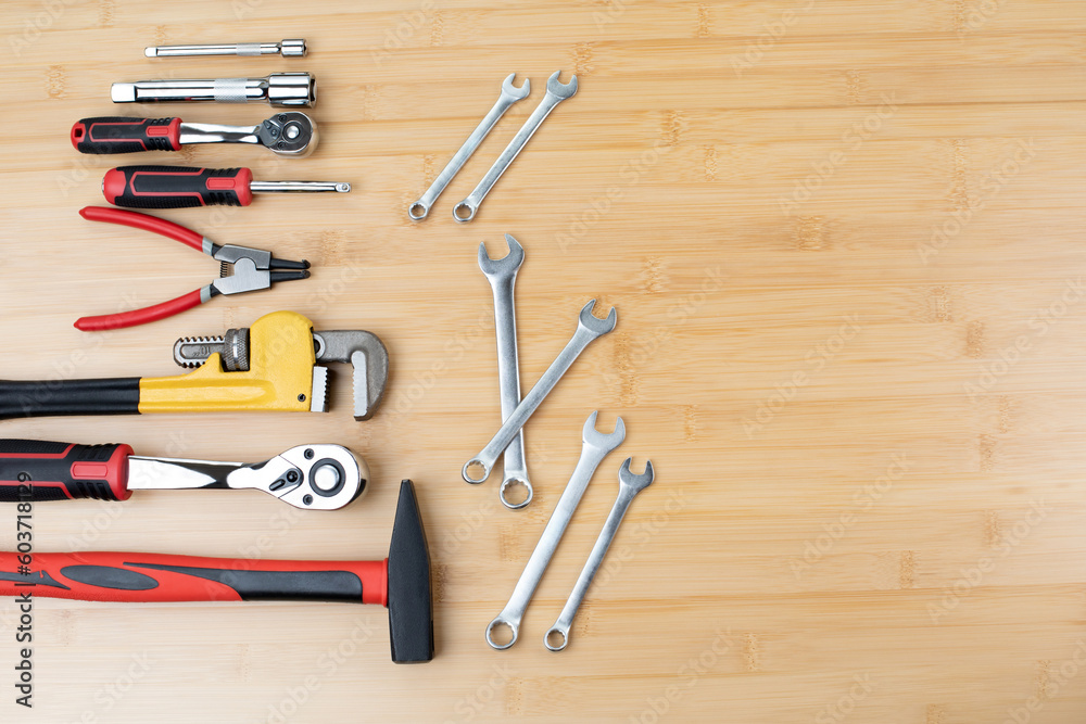 A set of working tools, a hammer, a pliers, a screwdriver, adjustable spanner, sockets for repair on a bamboo, wooden background. Flat lay A set of working tools, a hammer, a pliers, a screwdriver, adjustable spanner, sockets for repair on a bamboo, wooden background. Flat lay