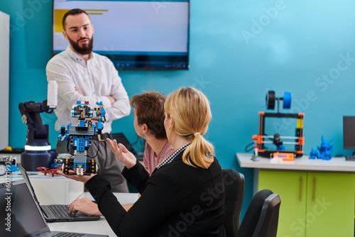 A group of colleagues working together in a robotics laboratory, focusing on the intricate fields of robotics and 3D printing. Showcase their dedication to innovation, as they engage in research
